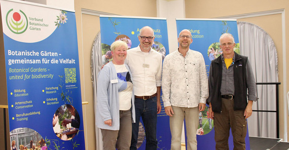 Vier Personen posieren für ein Gruppenbild.