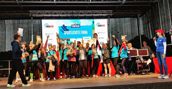 Menschen auf einer Bühne freuen sich über eine Auszeichnung