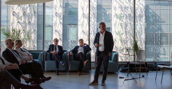 A man speaks in front of others at an event