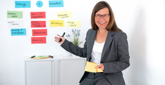 Carola Machnik vor einer Wand mit Notizzetteln.