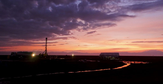 Bild mit Sonnenuntergang und Bohrturm im Hintergrund