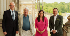 Vier Personen stehen auf der Freitreppe des Süd-Communs