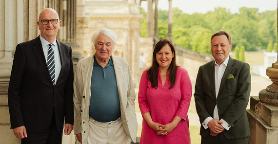 Vier Personen stehen auf der Freitreppe des Süd-Communs