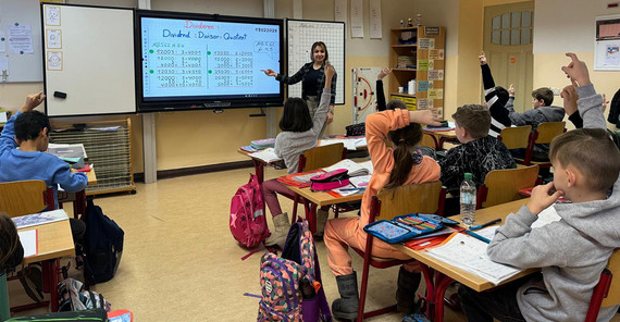 Entisar Karkoli in Unterrichtssituation mit Schulklasse.