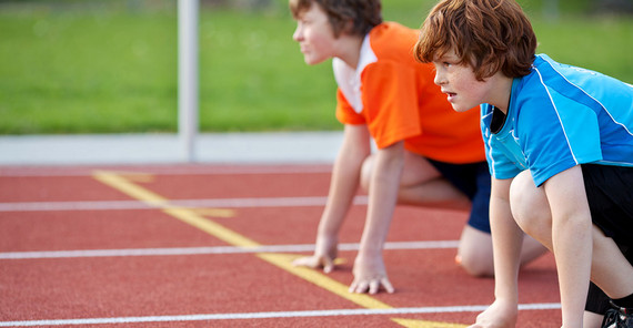 Zwei Jungen in Startposition für einen Lauf.