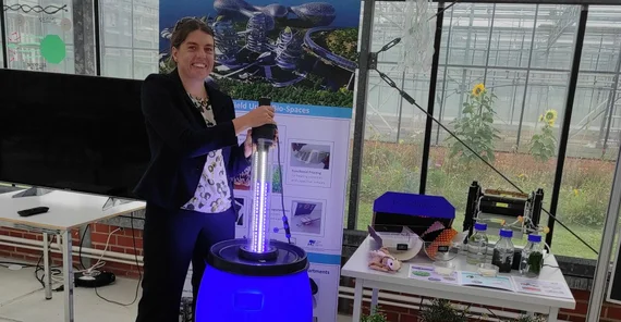 Dr. Anna Fricke mit Lichtschwert am Algenfass.