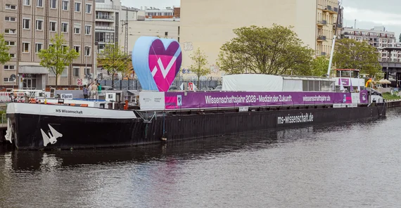 Die MS Wissenschaft an einem Stadtufer.