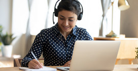 Studentin im Homeoffice sitzt am Laptop un arbeitet. Das Foto ist von AdobeStock/fizkes.