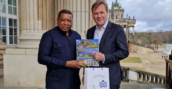 Zwei Menschen posieren für ein Bild. Sie schütteln Hände.