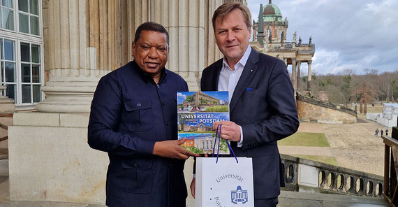 Zwei Menschen posieren für ein Bild. Sie schütteln Hände.