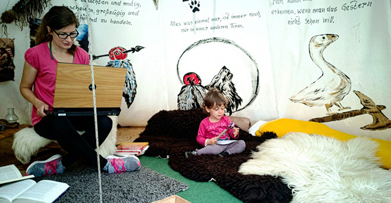FRau mit Laptop in Tipi, daneben ihr Kind. Foto: Alexandra Richter