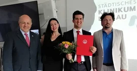 Drei Männer und eine Frau auf einem Gratulationsfoto