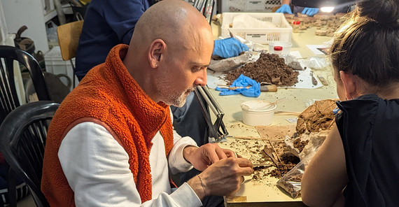 Zwei Menschen sitzen an einem Tisch und arbeiten an etwas