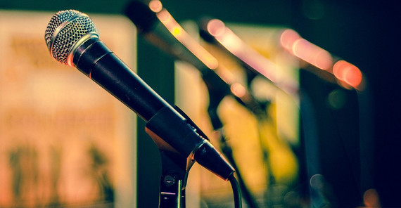 Landesweit treten Wissenschaftlerinnen und Wissenschaftler auf offener Bühne in den Wettstreit. Auf dem Symbolbild ist ein Mikrofon auf einem Ständer zu sehen, der Hintergrund ist verschwommen. Das Bild ist von Skitterphoto/Pixabay.