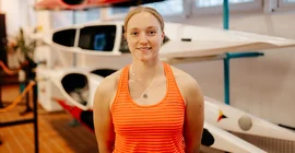 Hannah Spielhagen im Portrait in Sportkleidung vor Kanus.